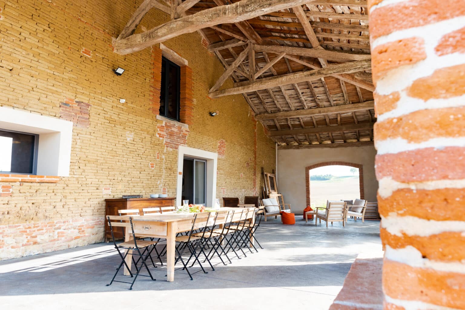 Grande table dressée pour un dîner d’accueil dans une grange rénovée près de Toulouse
