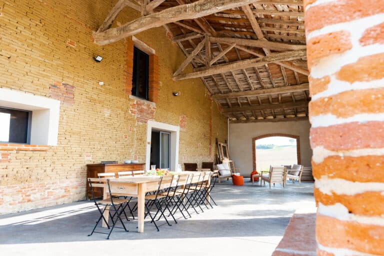 Grande table dressée pour un dîner d’accueil dans une grange rénovée près de Toulouse
