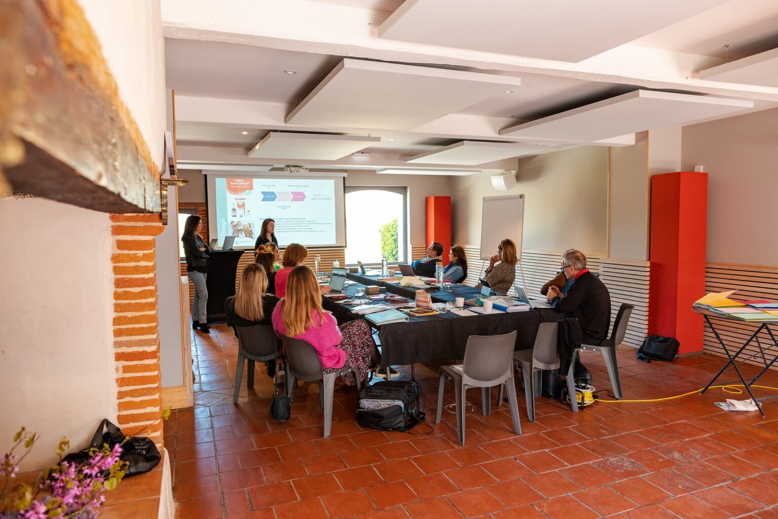 Participants en séminaire dans une salle de réunion conviviale avec présentation à Toulouse